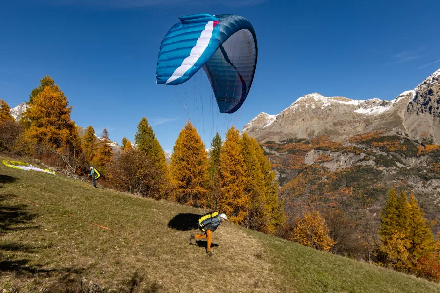 AirDesign Eazy 4 canopy rising above a pilot on a grassy mountain slope